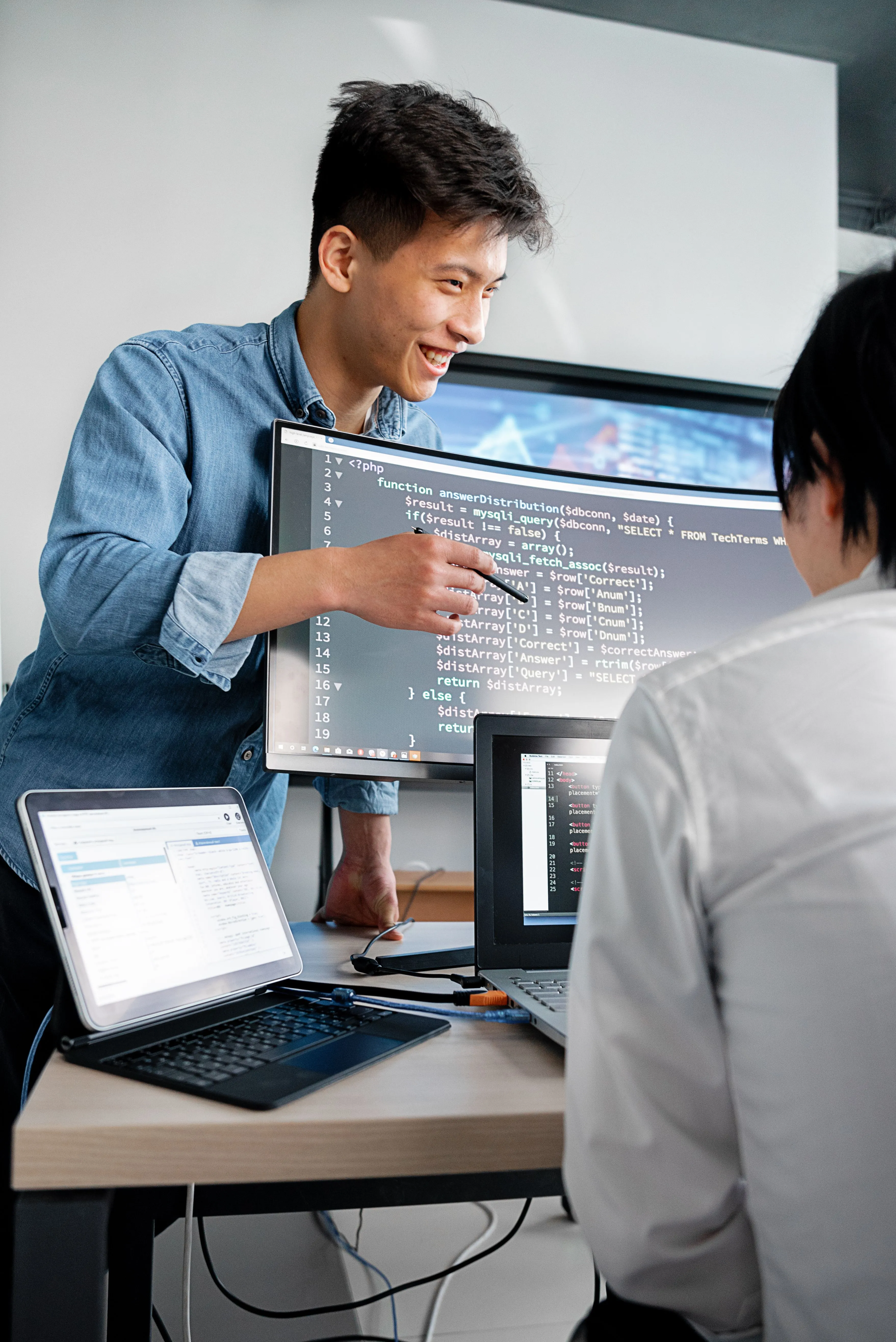 Profesionales analizando y explicando una solución tecnológica mediante diferentes dispositivos digitales.